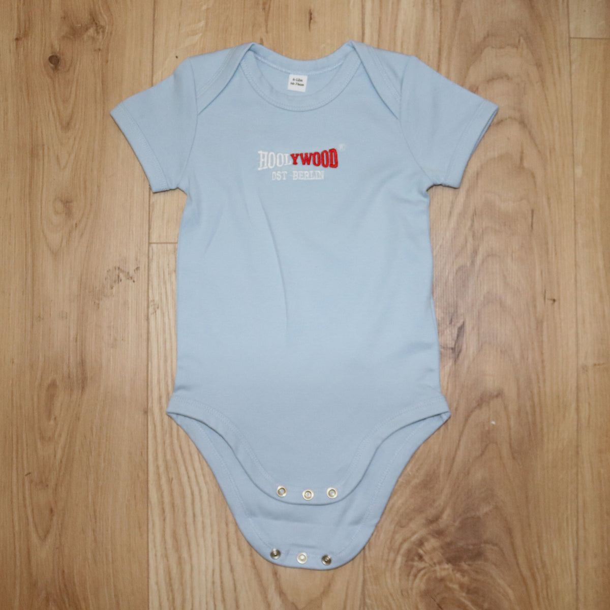 HOOLYWOOD Strampler Baby Bodysuit mit hochwärtigen 2 farbigen HOOLYWOOD-OST BERLIN Stick (hellblau - skyblue)